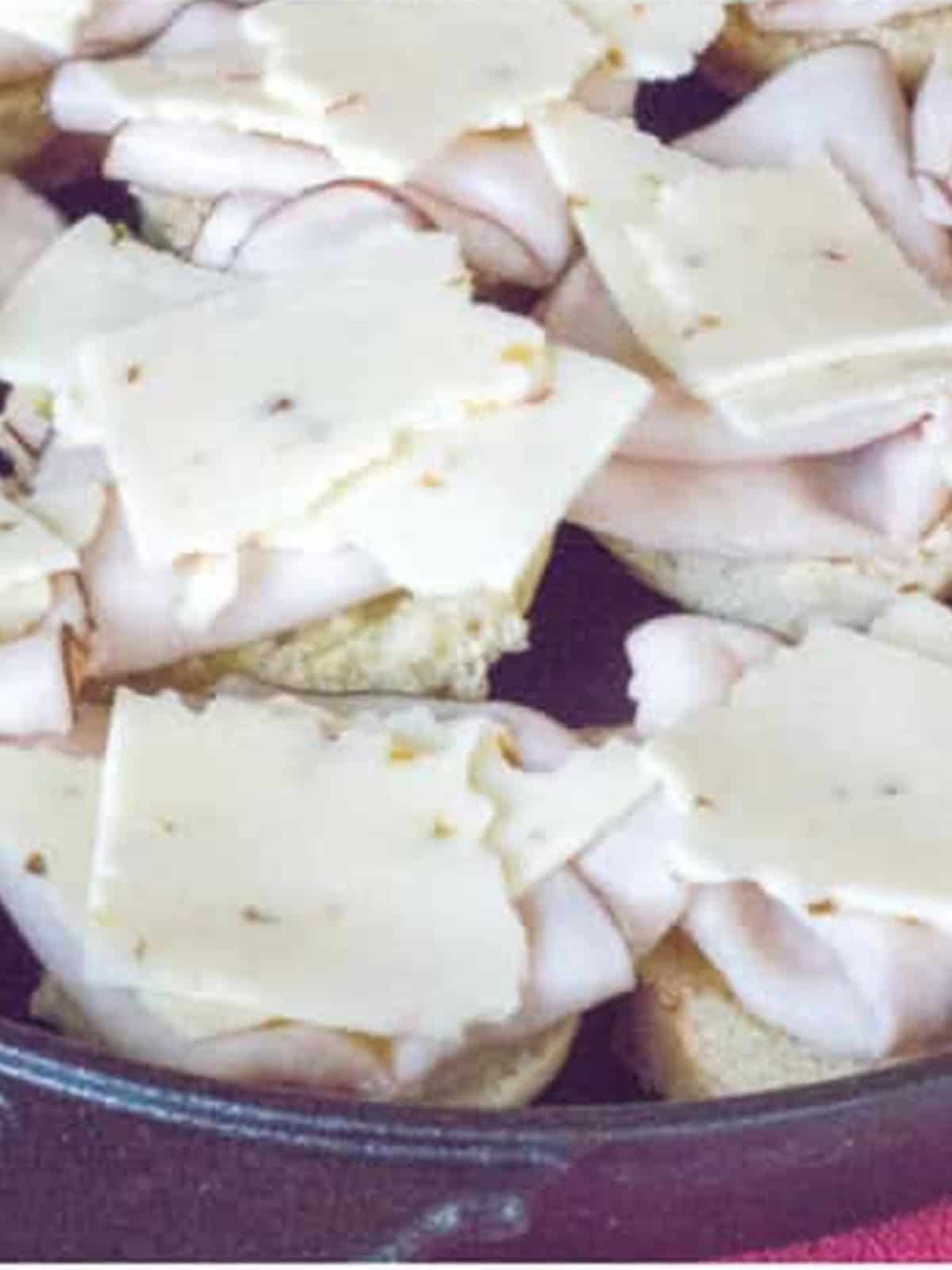 Pepper jack cheese slices layered on top of the turkey in the skillet.