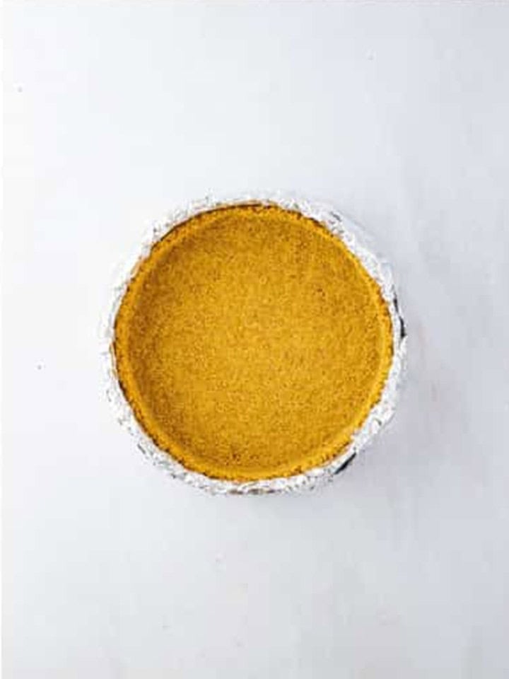 Graham cracker crust pressed into the bottom of a foil wrapped springform pan.