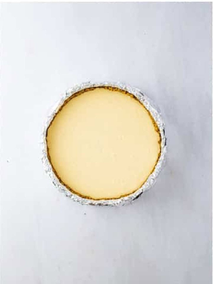 Cheesecake filling poured over the crust and smoothed in the foil wrapped pan.