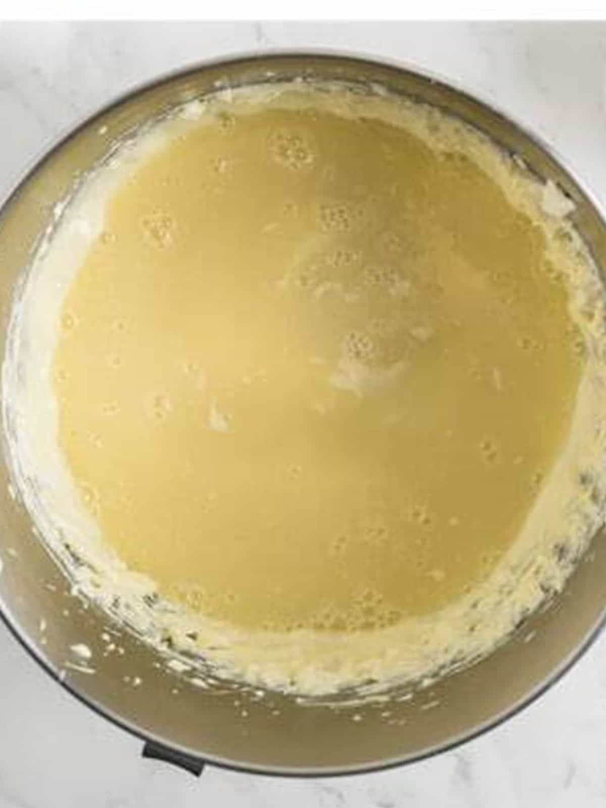 Smooth cream cheese filling beaten with sugar, sour cream, eggs, and melted white chocolate for White Chocolate Raspberry Cheesecake.