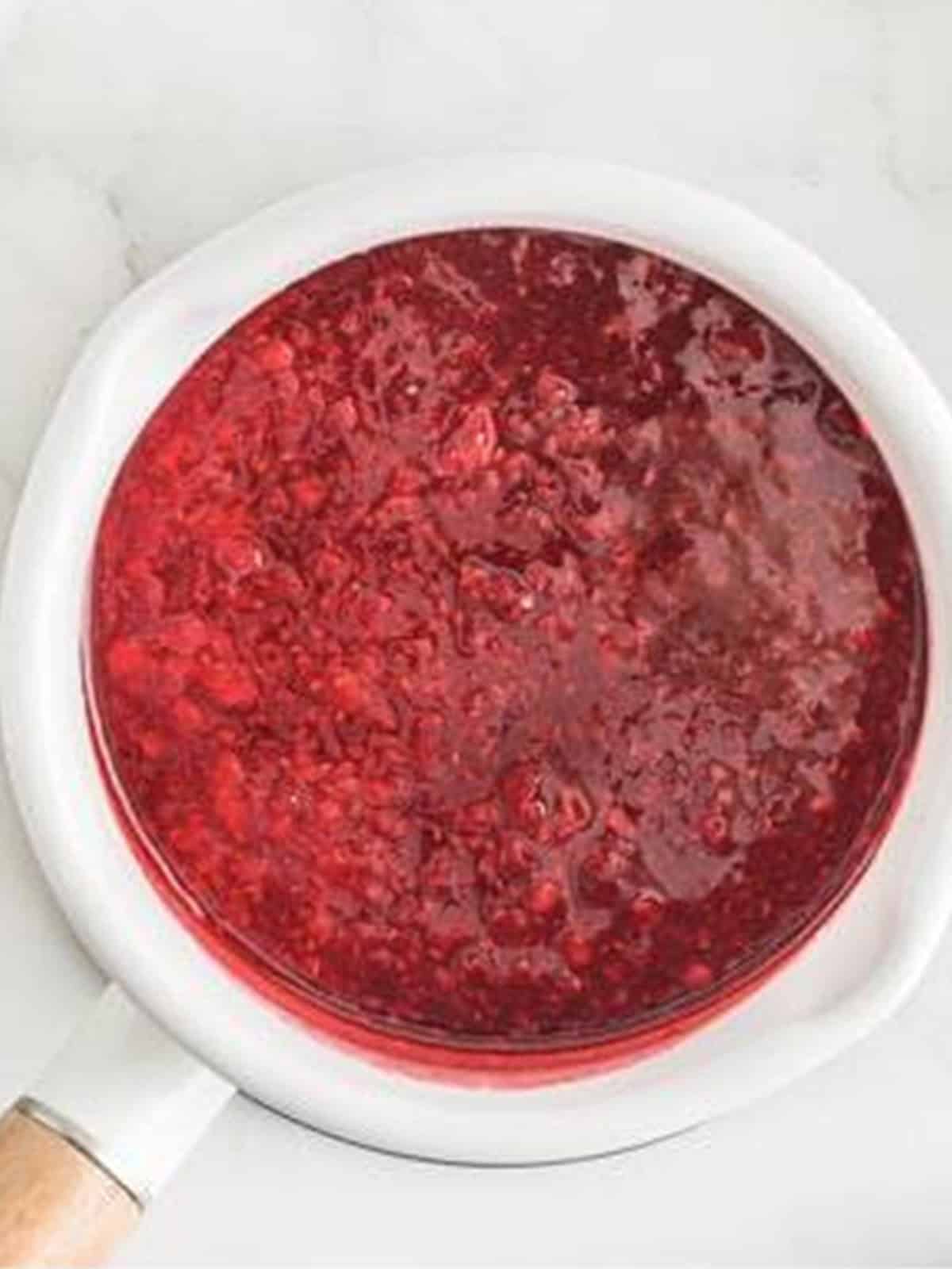 Raspberry swirl sauce cooked with sugar and lemon juice for White Chocolate Raspberry Cheesecake.