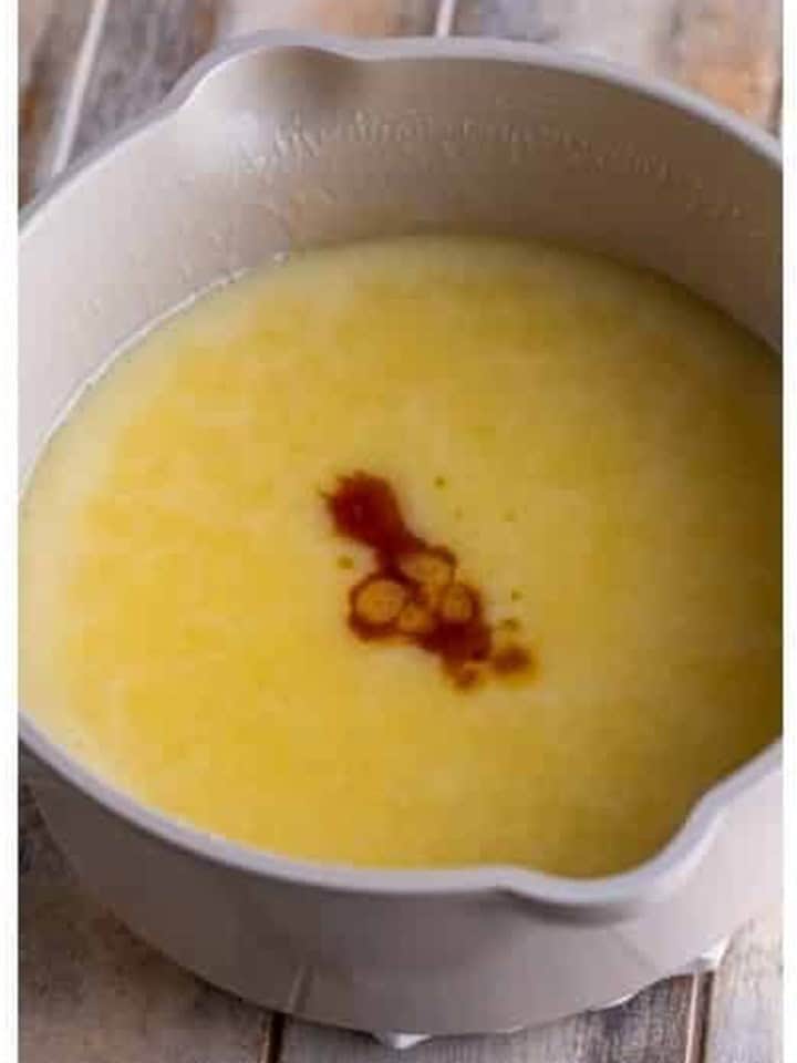 Vanilla extract added to the thickened white chocolate sauce off the heat.