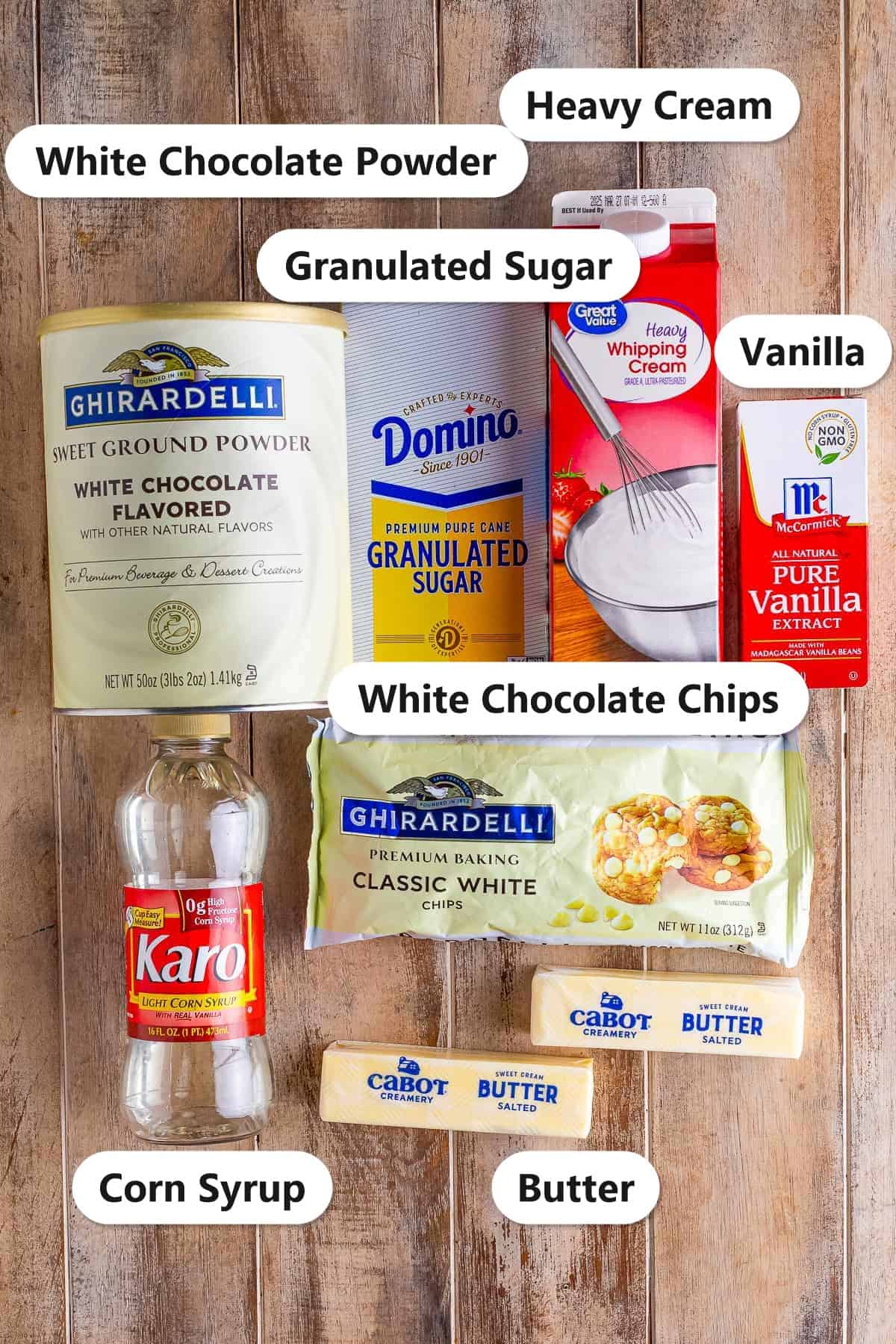 Labeled ingredients for White Chocolate Sauce: white chocolate powder, granulated sugar, heavy cream, vanilla, corn syrup, white chocolate chips, and butter.