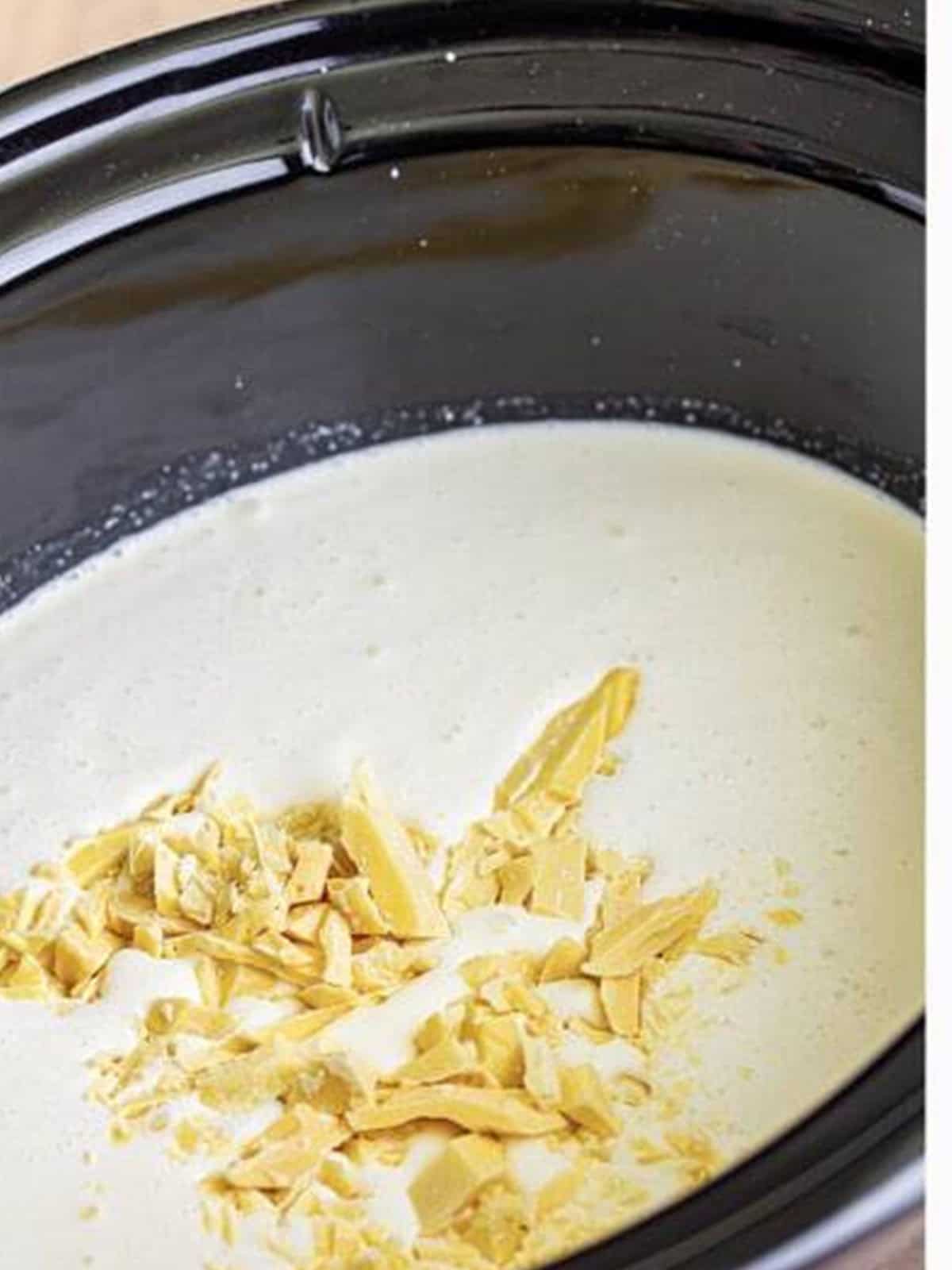 Chopped white chocolate added to the cream mixture in the slow cooker.