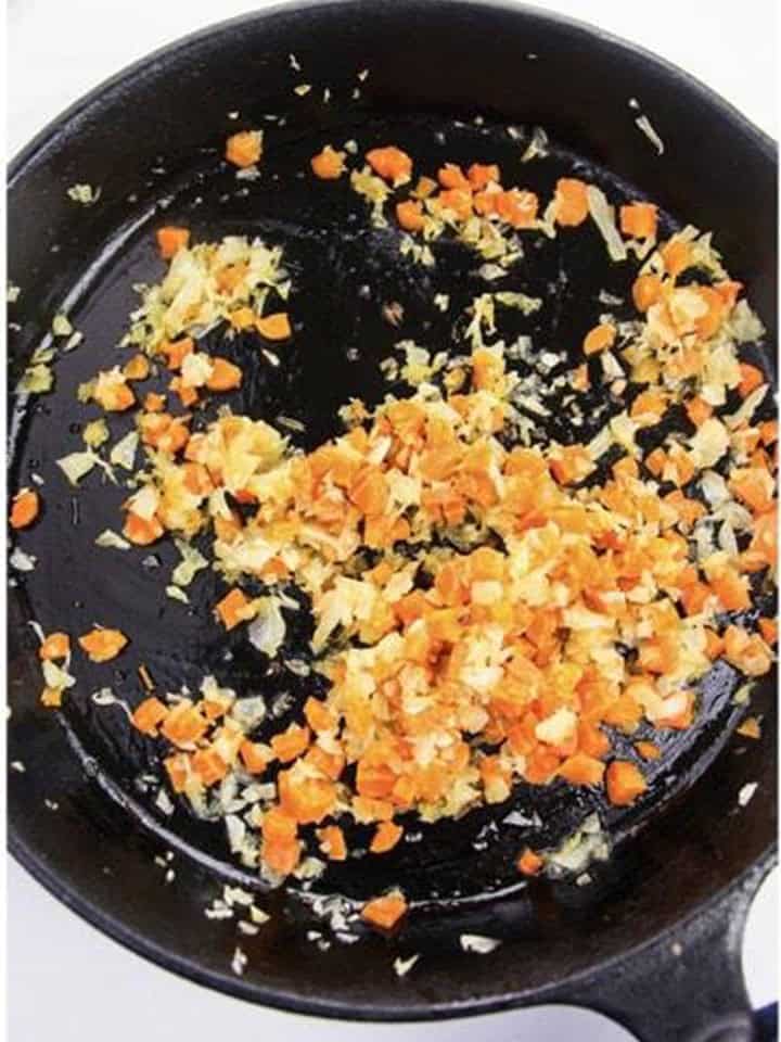 Sauteing minced onion and carrot in butter for Wild Rice Pilaf.