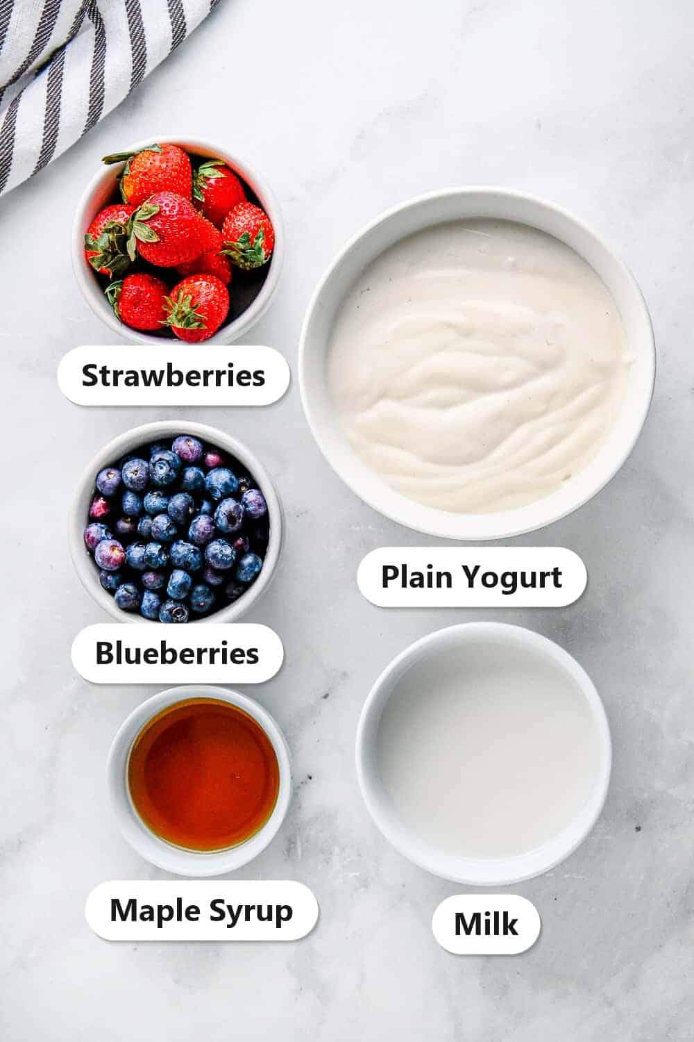 Labeled ingredients for Yogurt Bark including plain yogurt, milk, maple syrup, strawberries, and blueberries.