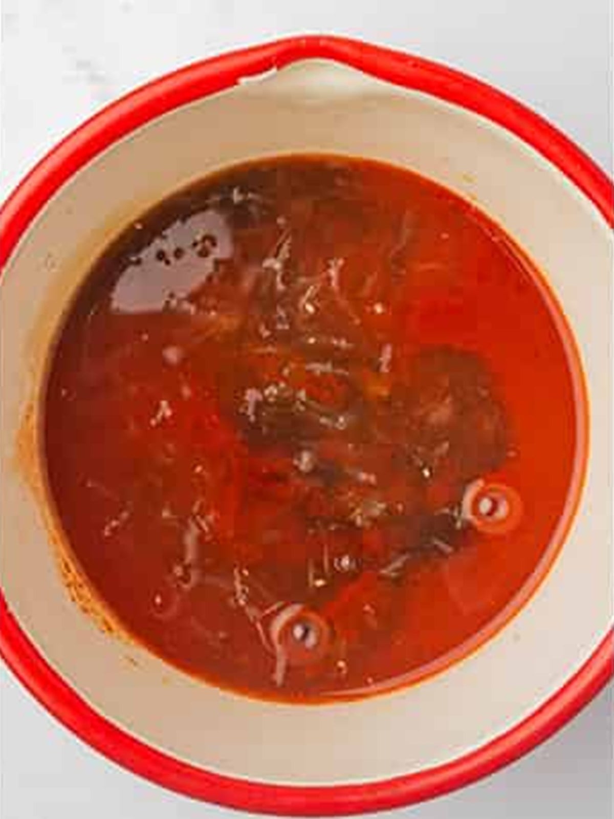 Honey sriracha glaze ingredients combined in a bowl before simmering.
