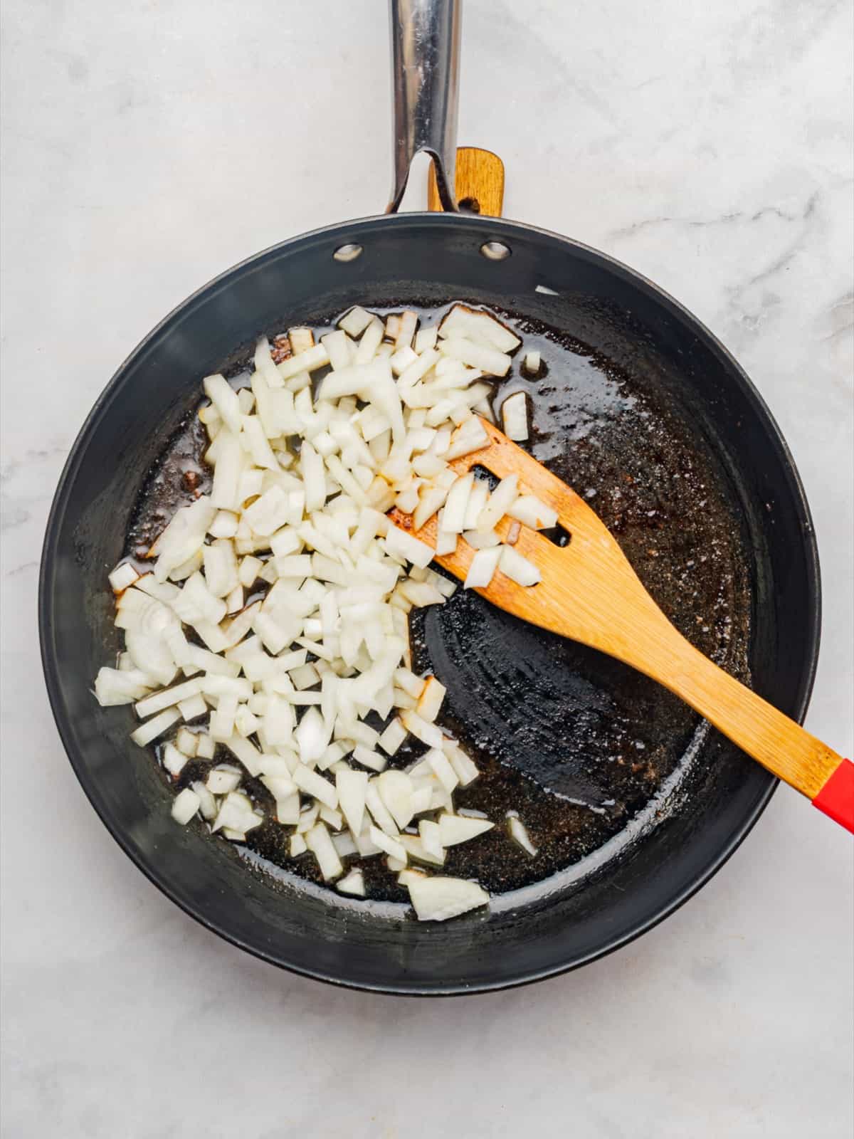 Chopped onion cooking in butter in the same skillet for beef stroganoff.