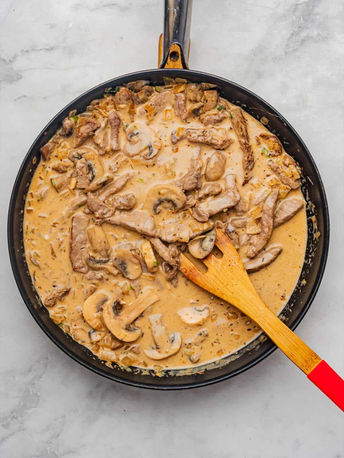 Seared sirloin strips returned to the creamy mushroom sauce in the skillet.