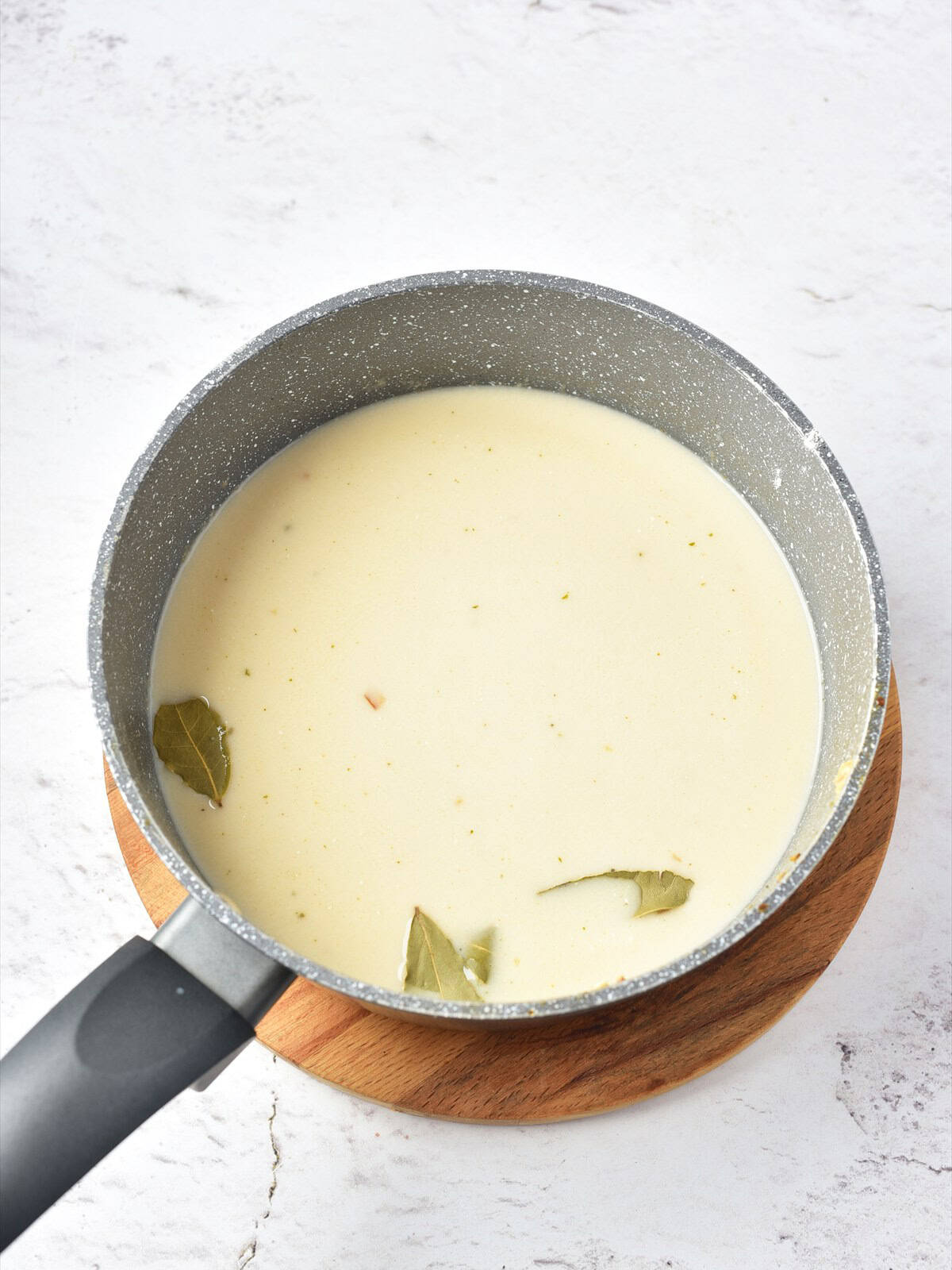 Chicken broth, cream and clam juice added to the roux with bay leaves for clam chowder.