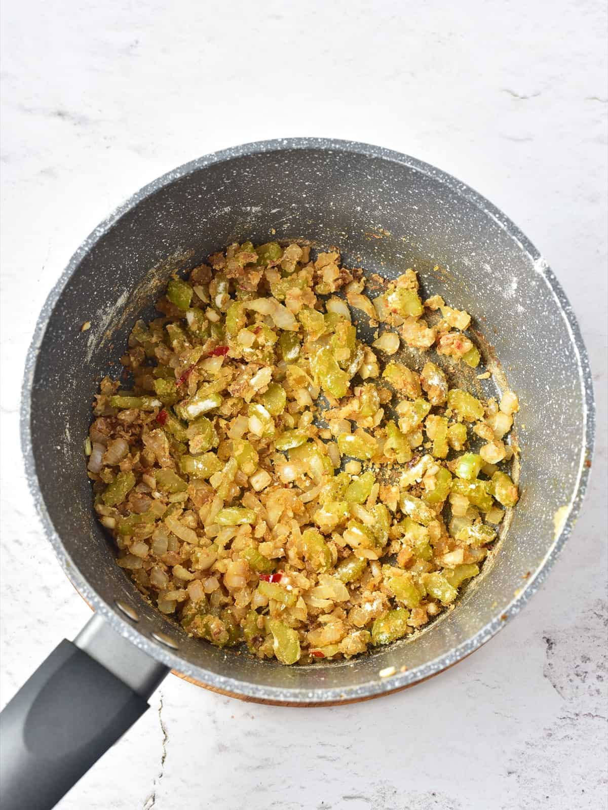 Flour stirred into the vegetables to form a thick roux for clam chowder.