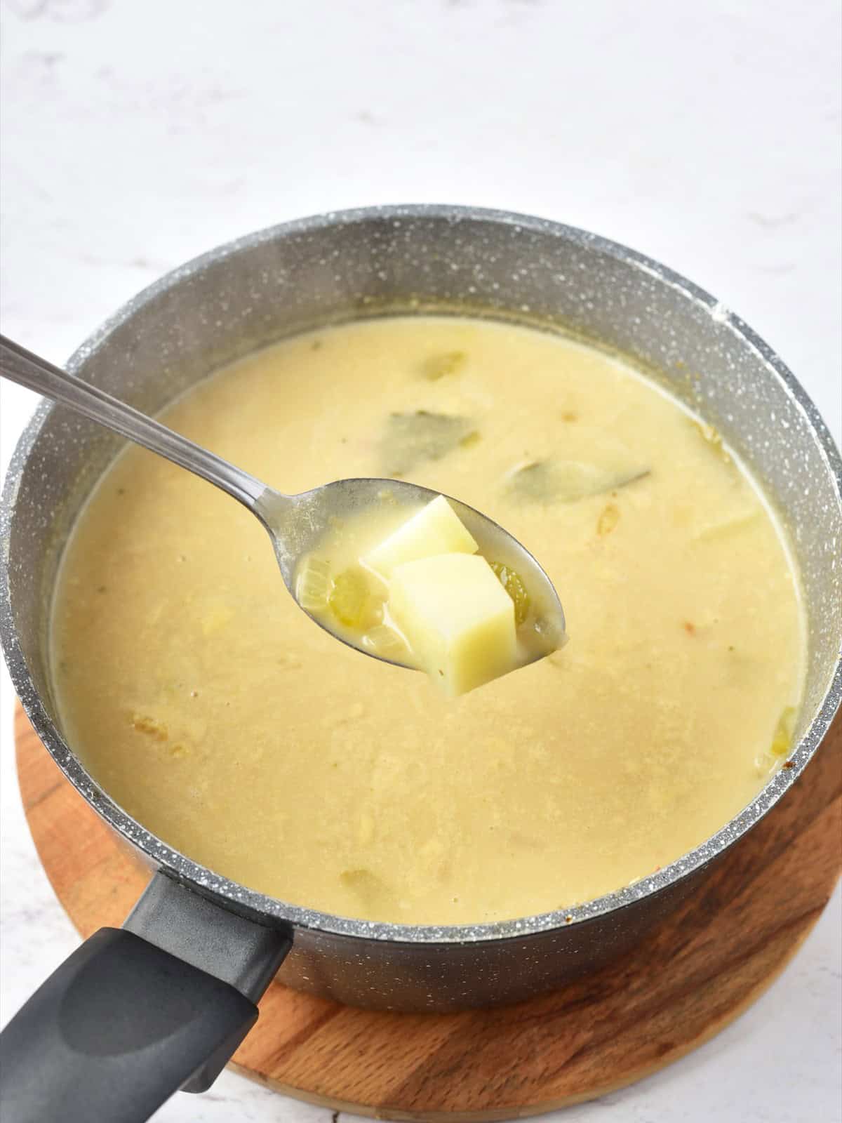 Diced potatoes simmering in the creamy chowder base until tender.