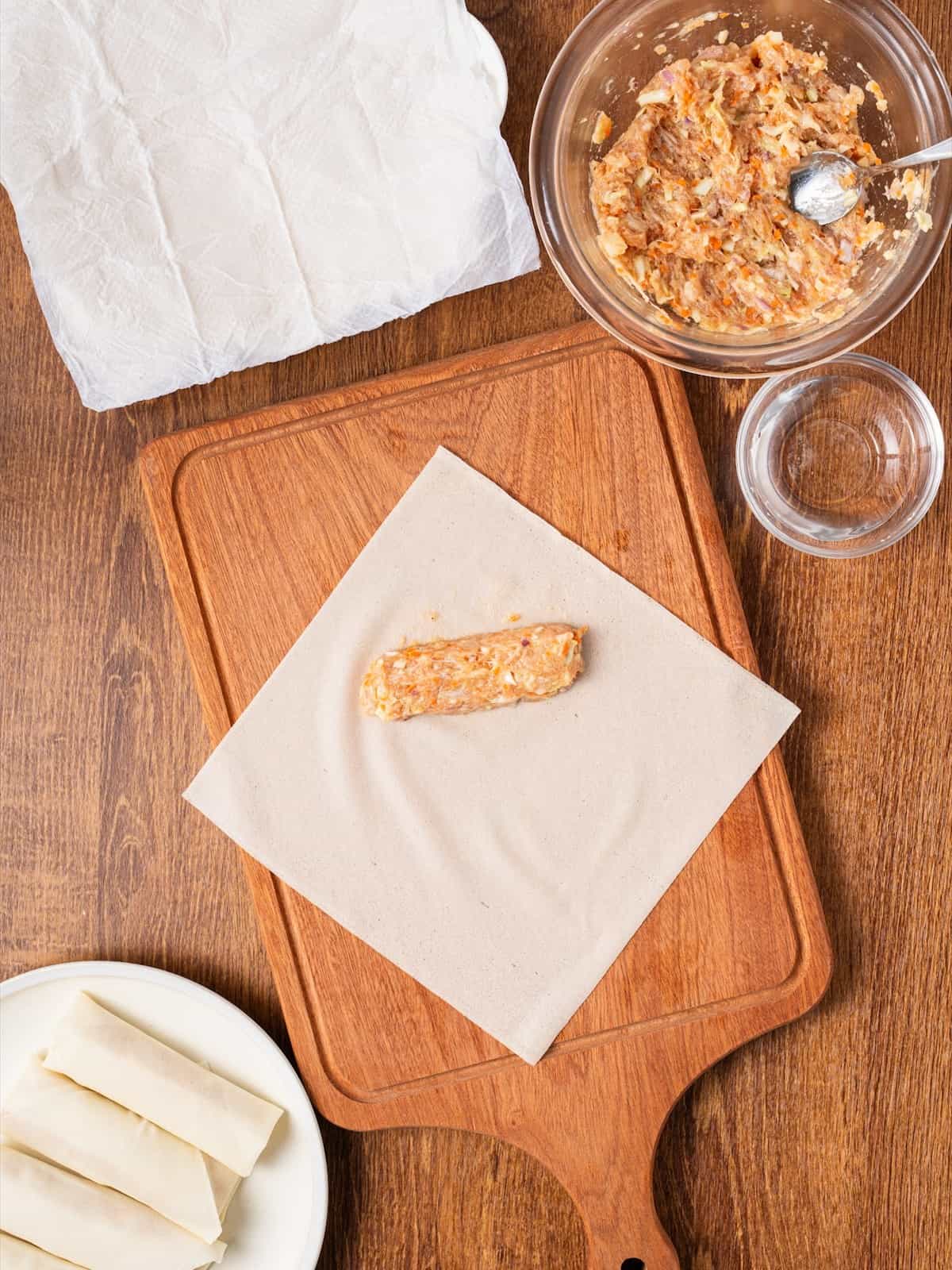 Lumpia filling shaped into a log on a spring roll wrapper