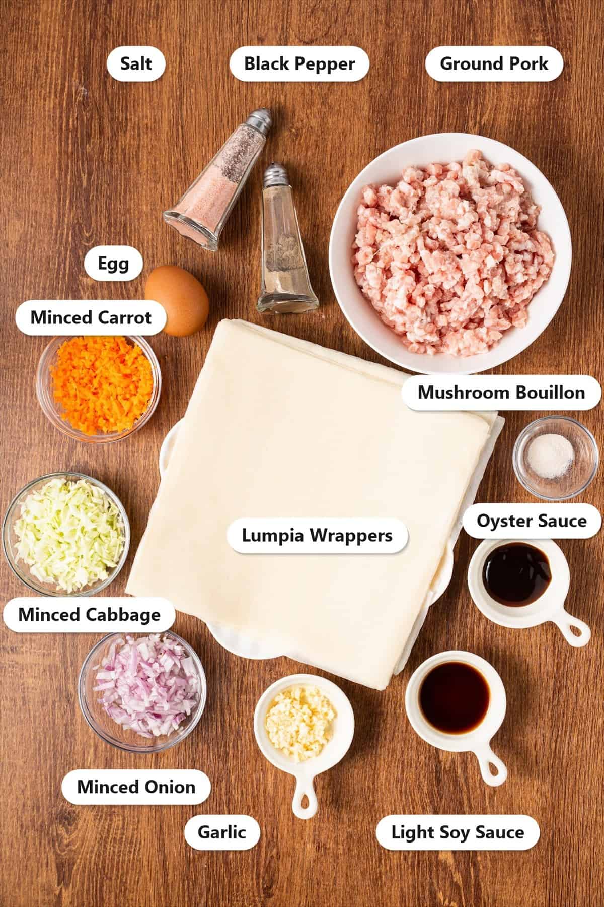 Labeled ingredients for Filipino lumpia including ground pork, carrot, cabbage, onion, garlic and lumpia wrappers