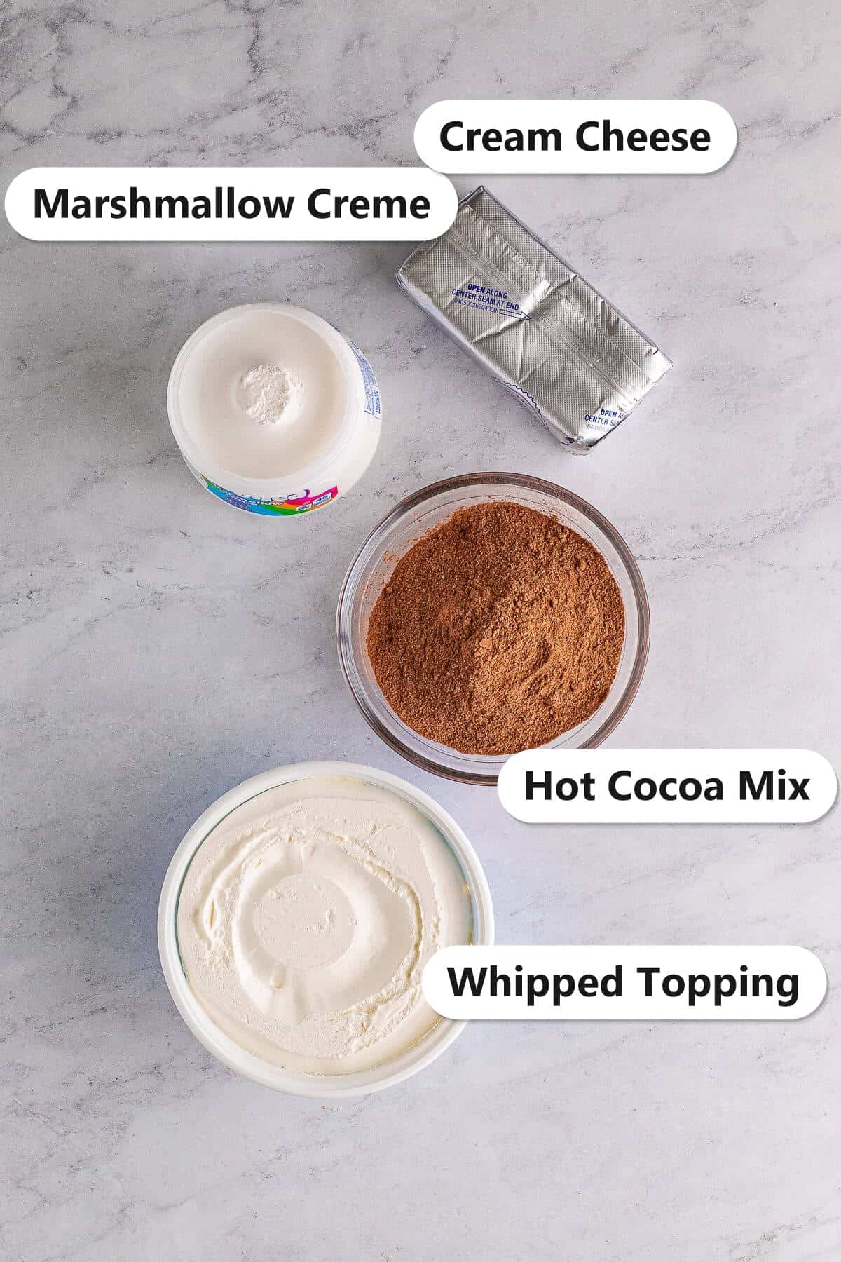 Labeled ingredients for hot chocolate dip including cream cheese, hot cocoa mix, marshmallow creme, and whipped topping.