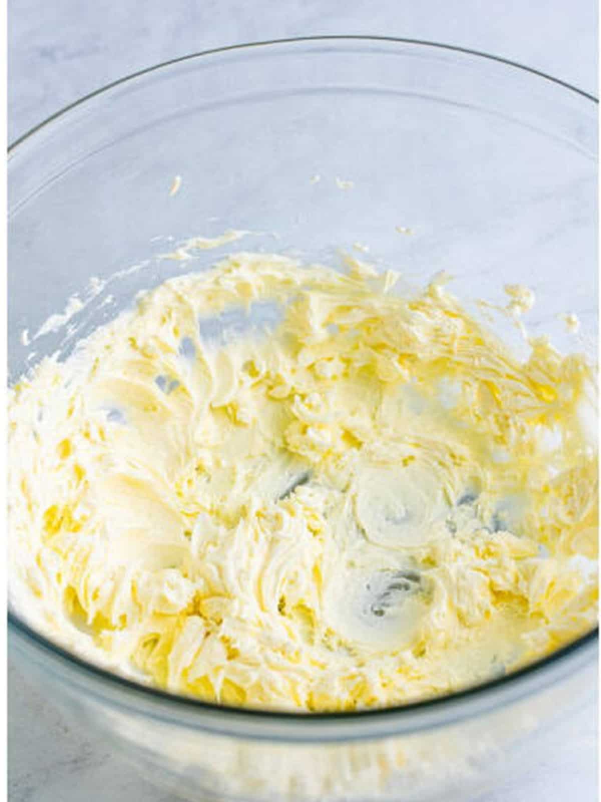 Cream cheese beaten until smooth in a glass mixing bowl for hot chocolate dip.