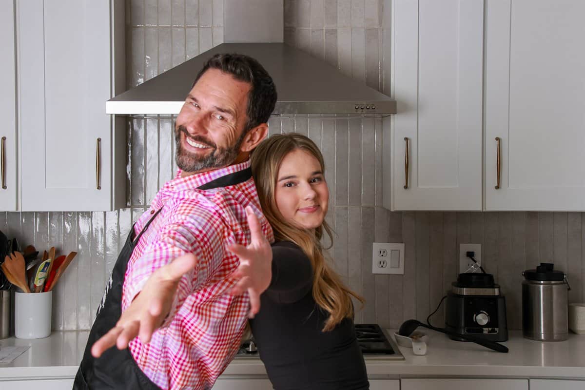 Jason Decker and his daughter Maddie laughing together in their kitchen.
