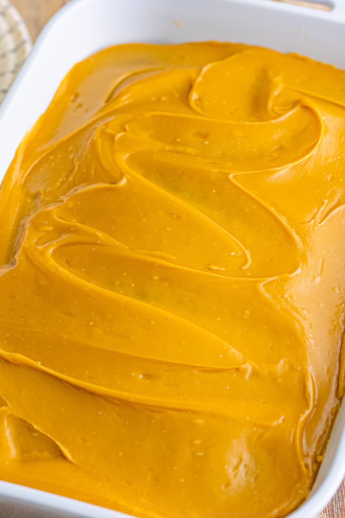 Warm brown sugar frosting spread over the cooled pumpkin spice cake.