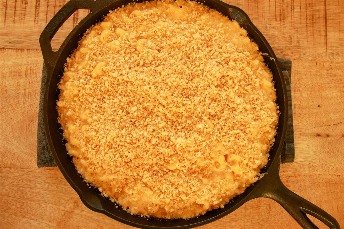 Smoked mac and cheese baked in a cast iron skillet with a golden brown panko topping.