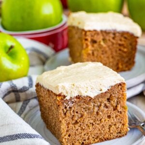 Slice of apple spice cake with brown sugar frosting on a plate showing the moist spiced crumb.