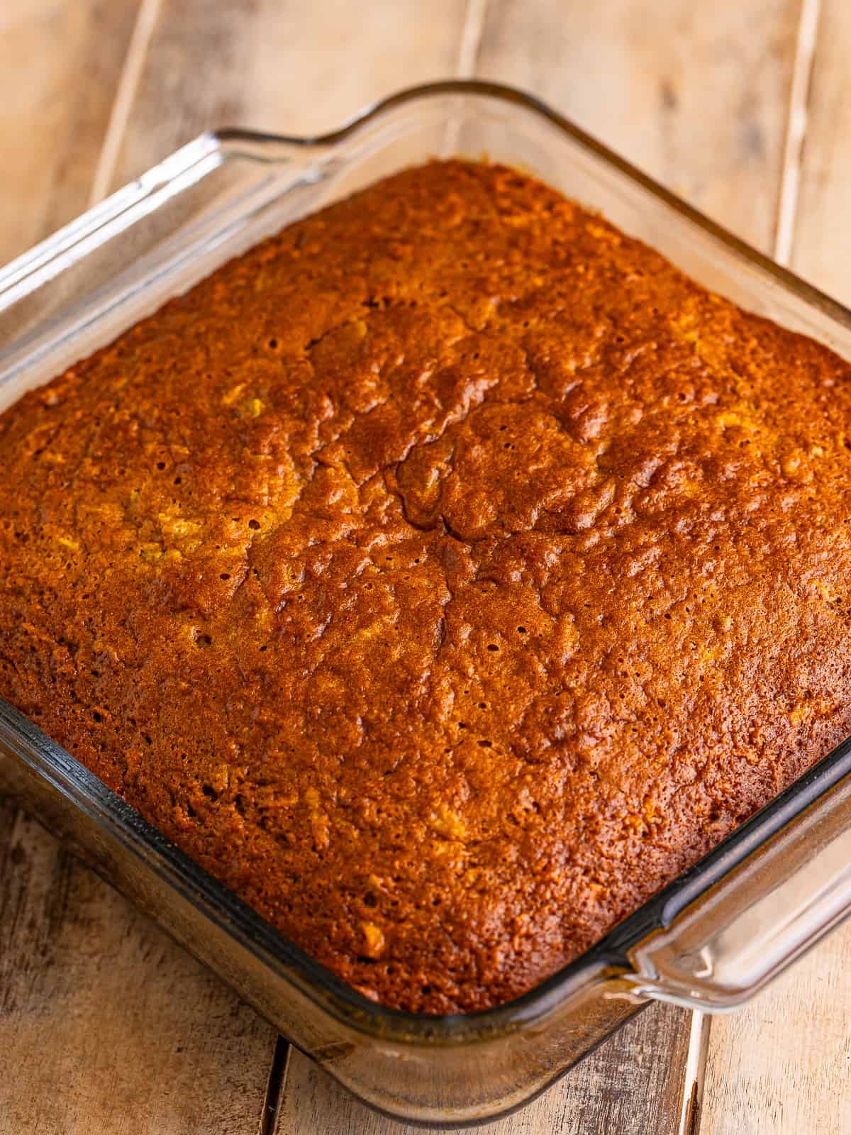 Baked apple spice cake, golden and set, cooling in the 8x8 baking dish.