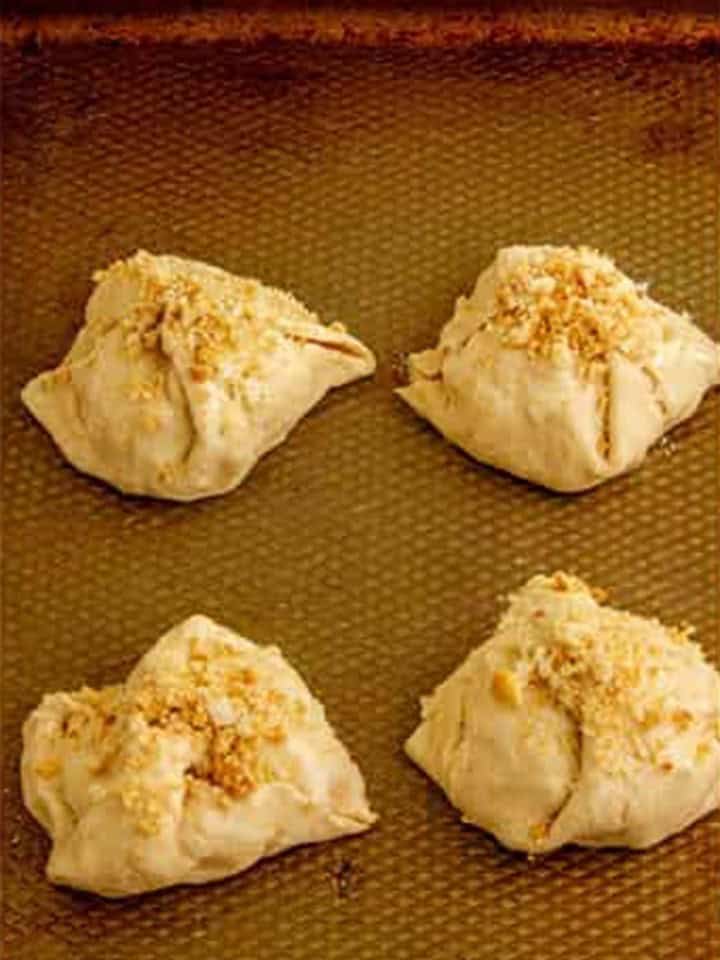 Crescent dough corners pulled up and sealed into bundles, brushed with butter and coated with crushed croutons.