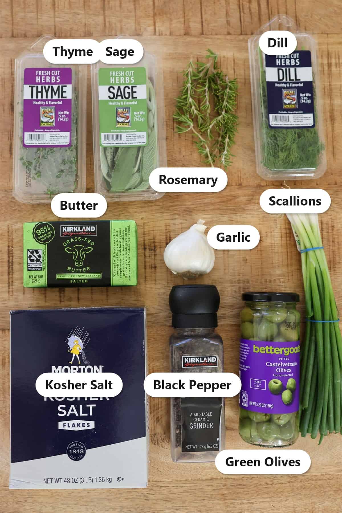 Labeled ingredients for compound butter including butter, kosher salt, black pepper, thyme, sage, rosemary, dill, scallions, garlic, and green olives.