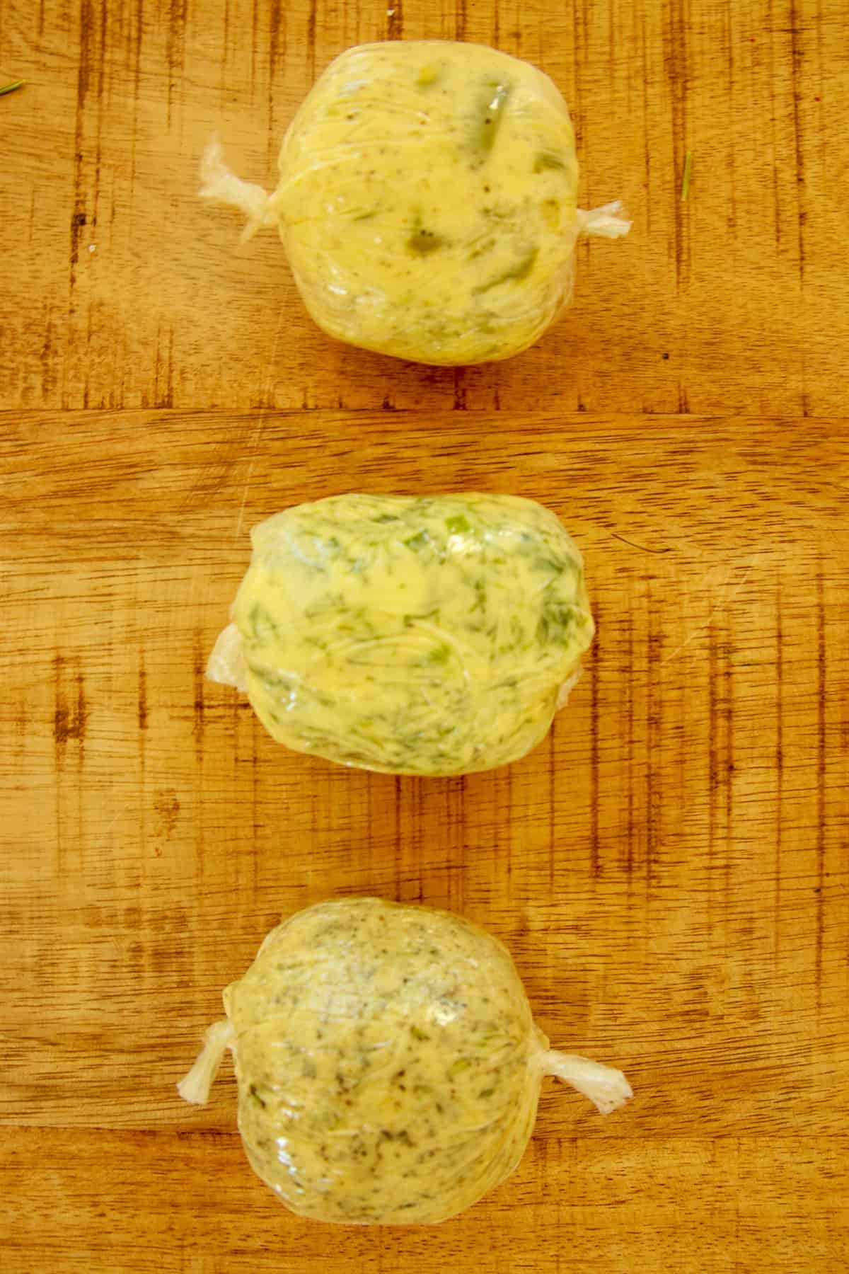 Compound butter rolled into logs in plastic wrap with the ends twisted closed, chilling until firm.