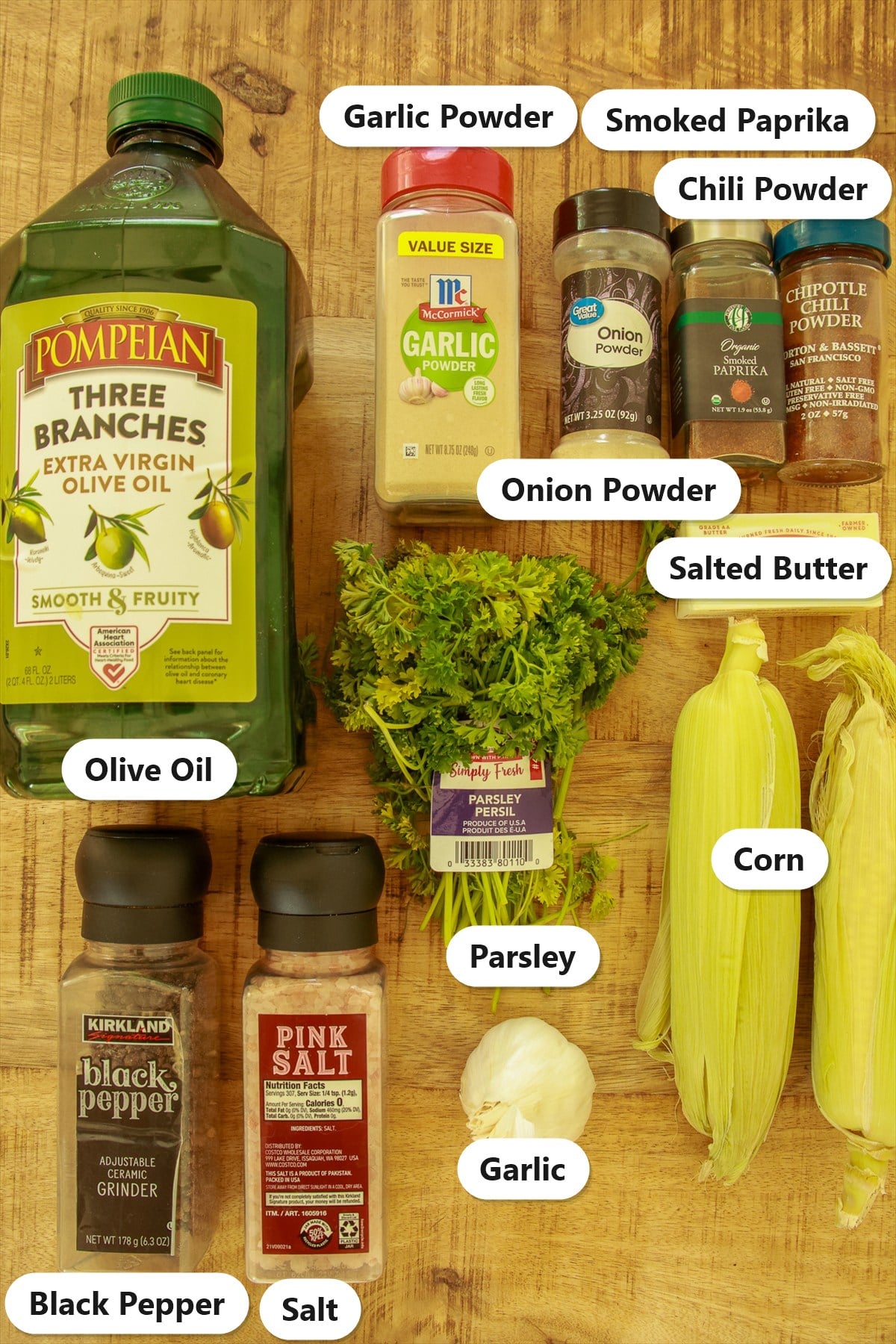 Labeled ingredients for corn ribs including corn on the cob, olive oil, spices, salted butter, garlic, and parsley.