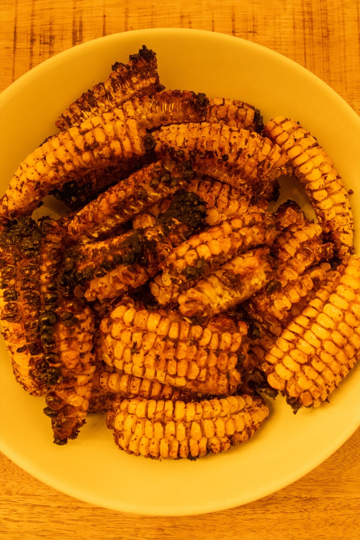 Grilled corn ribs with charred curled edges in a bowl fresh off the Traeger.