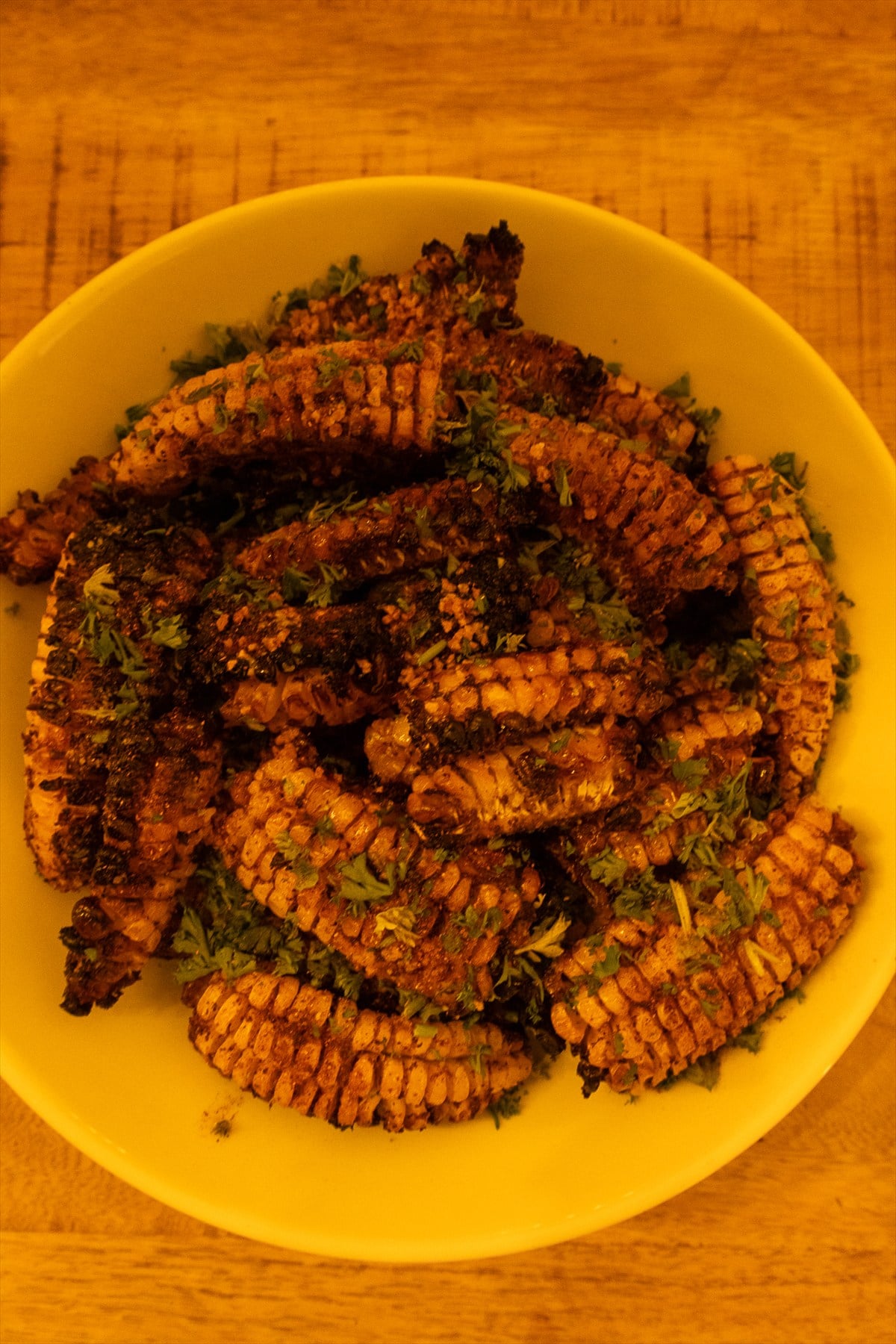 Corn ribs brushed with garlic butter and sprinkled with chopped parsley.