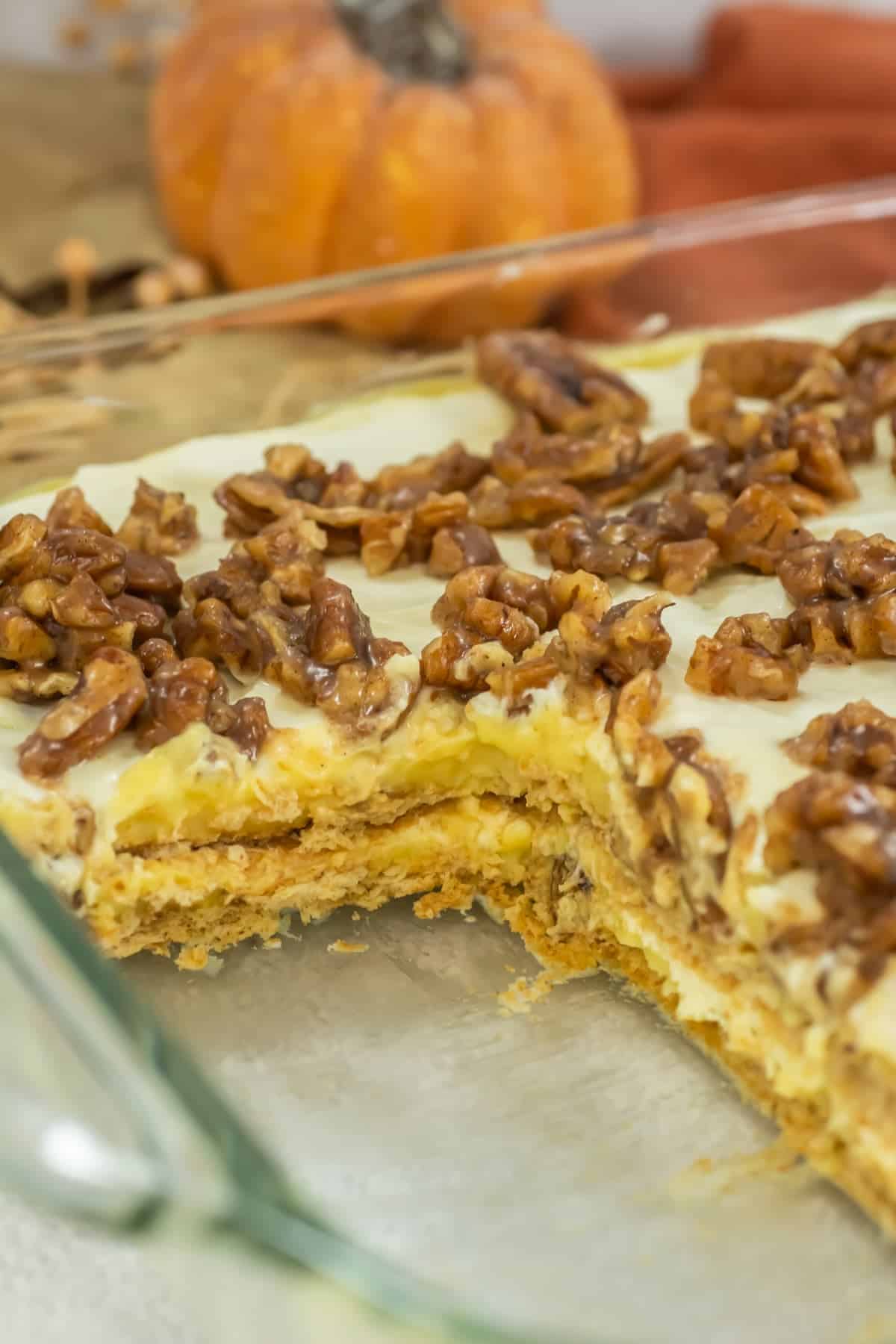 No-bake pecan pie lasagna in a glass dish with layers of graham crackers, cream filling, and candied pecans.