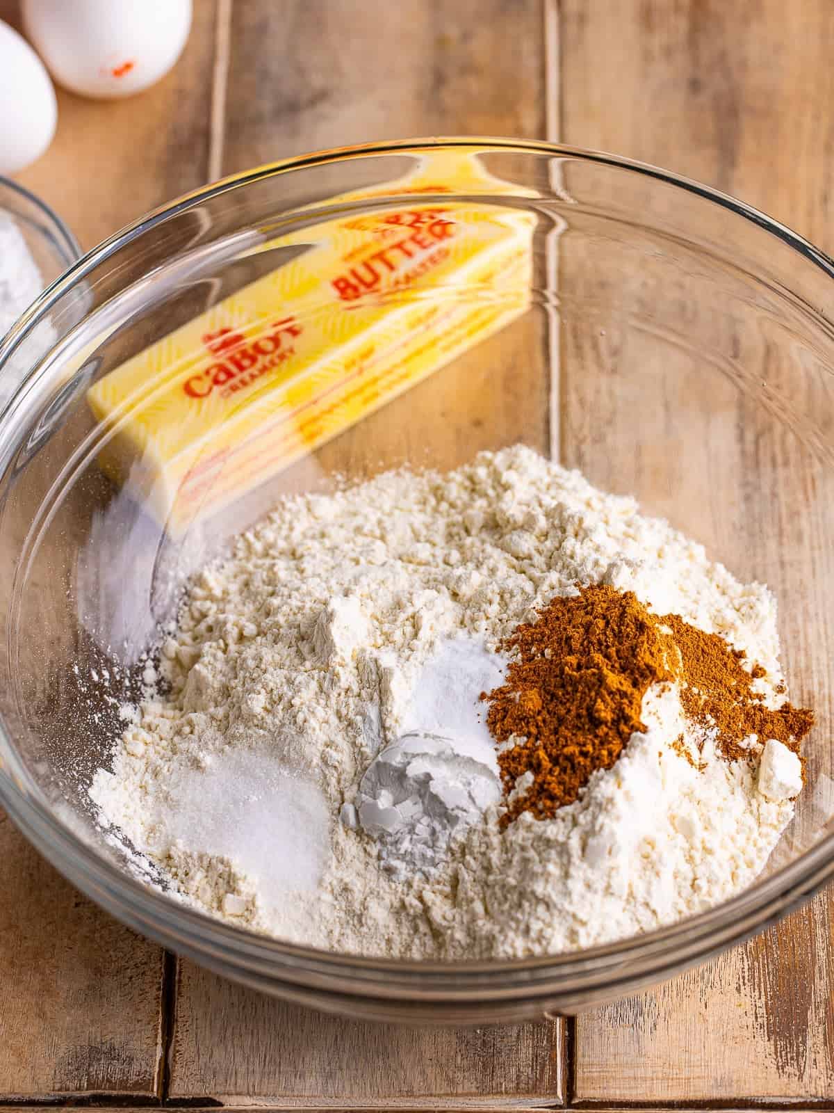 Flour, pumpkin pie spice, baking powder, baking soda and salt in a glass mixing bowl.