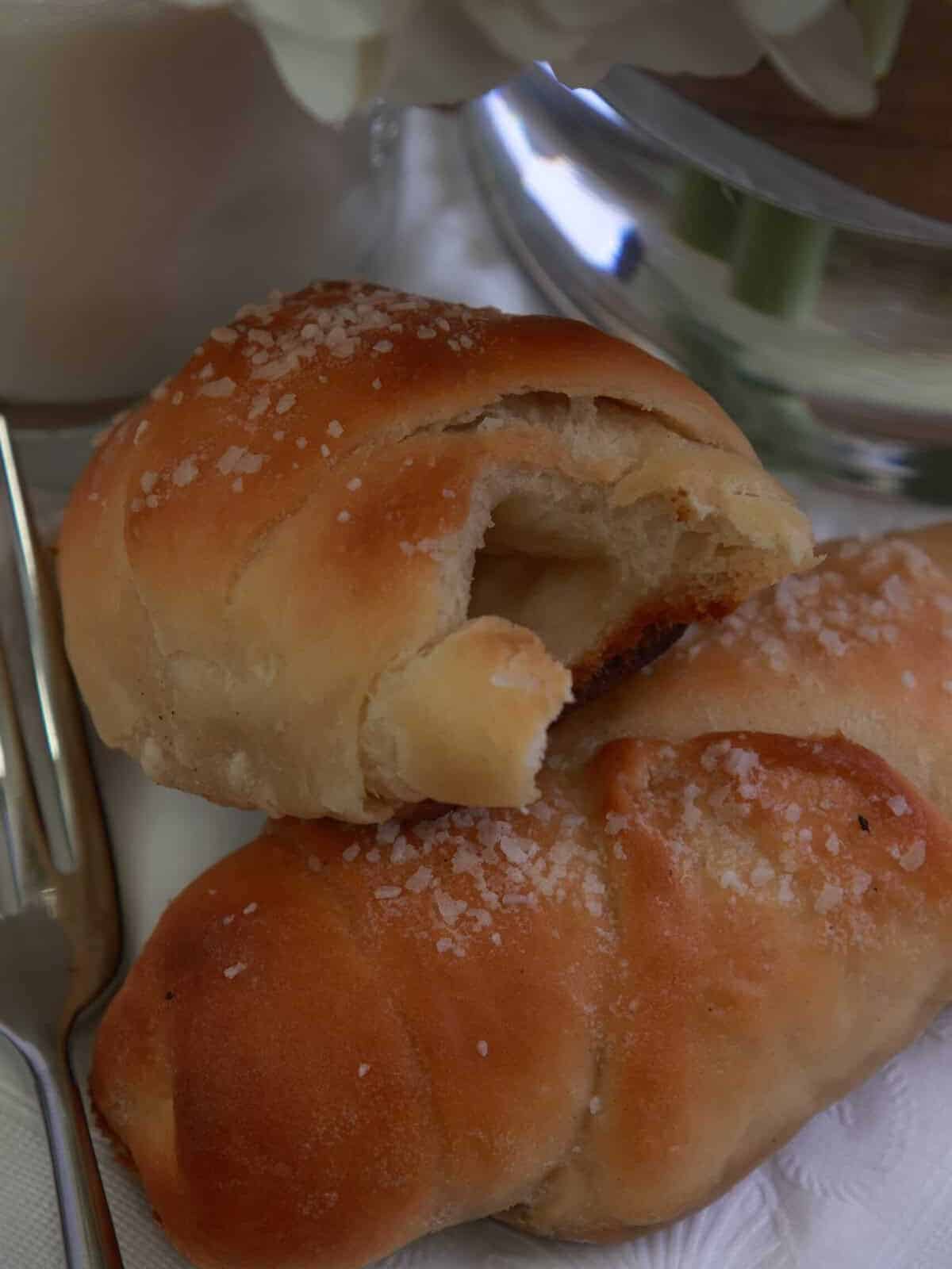 A torn salt bread roll showing the soft layered crumb and hollow buttery center.