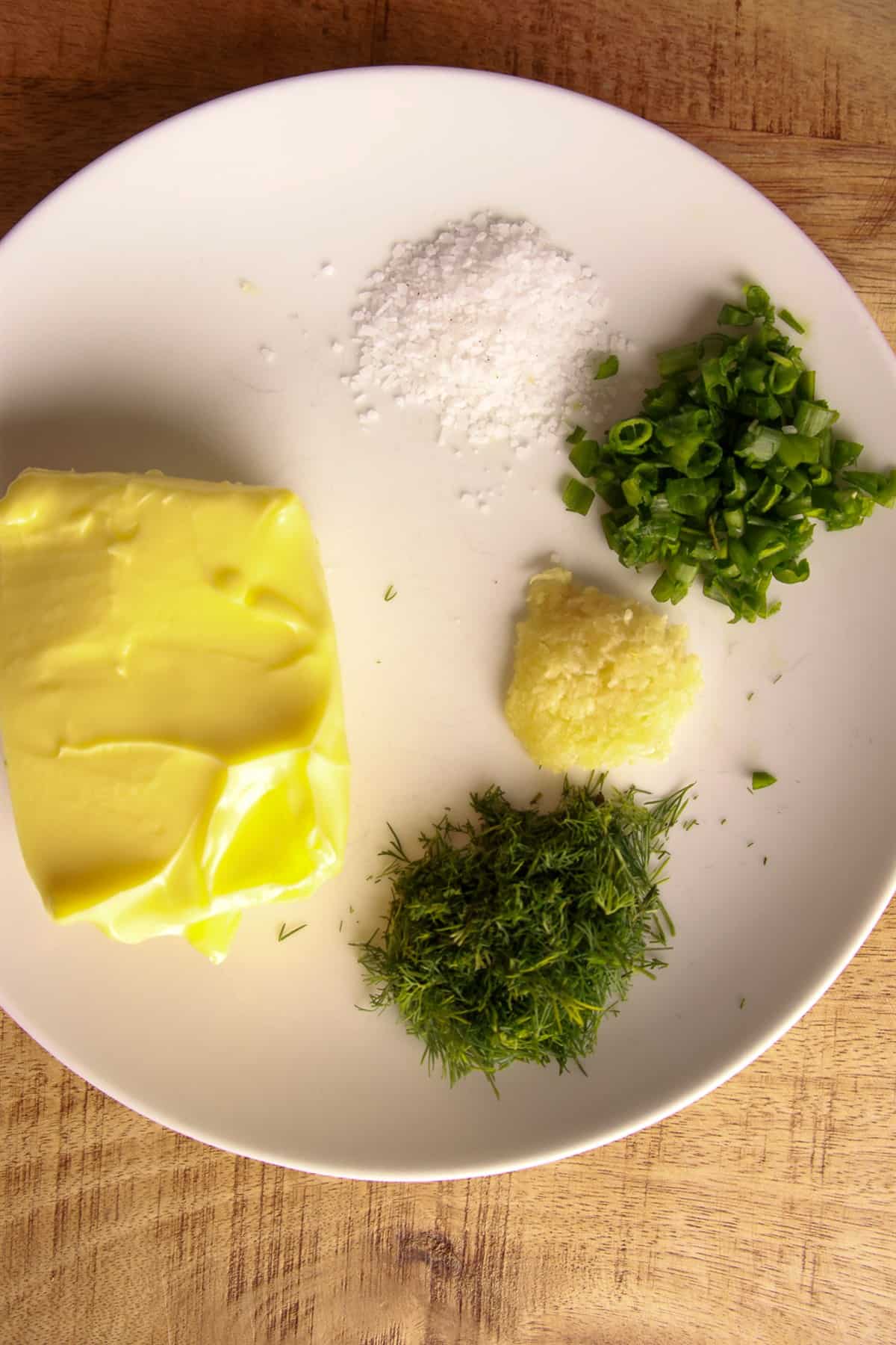 Softened butter with chopped scallions, fresh dill, garlic, and sea salt for scallion dill compound butter.
