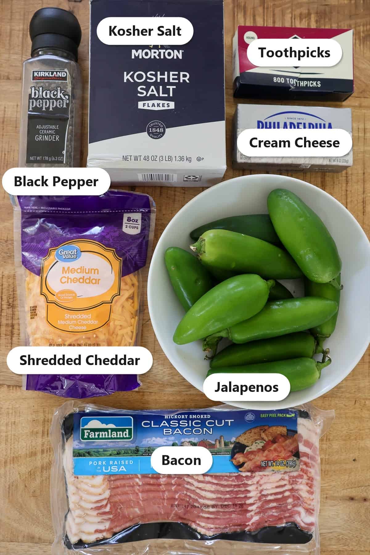 Labeled ingredients for smoked bacon wrapped jalapeno poppers on a wood board.