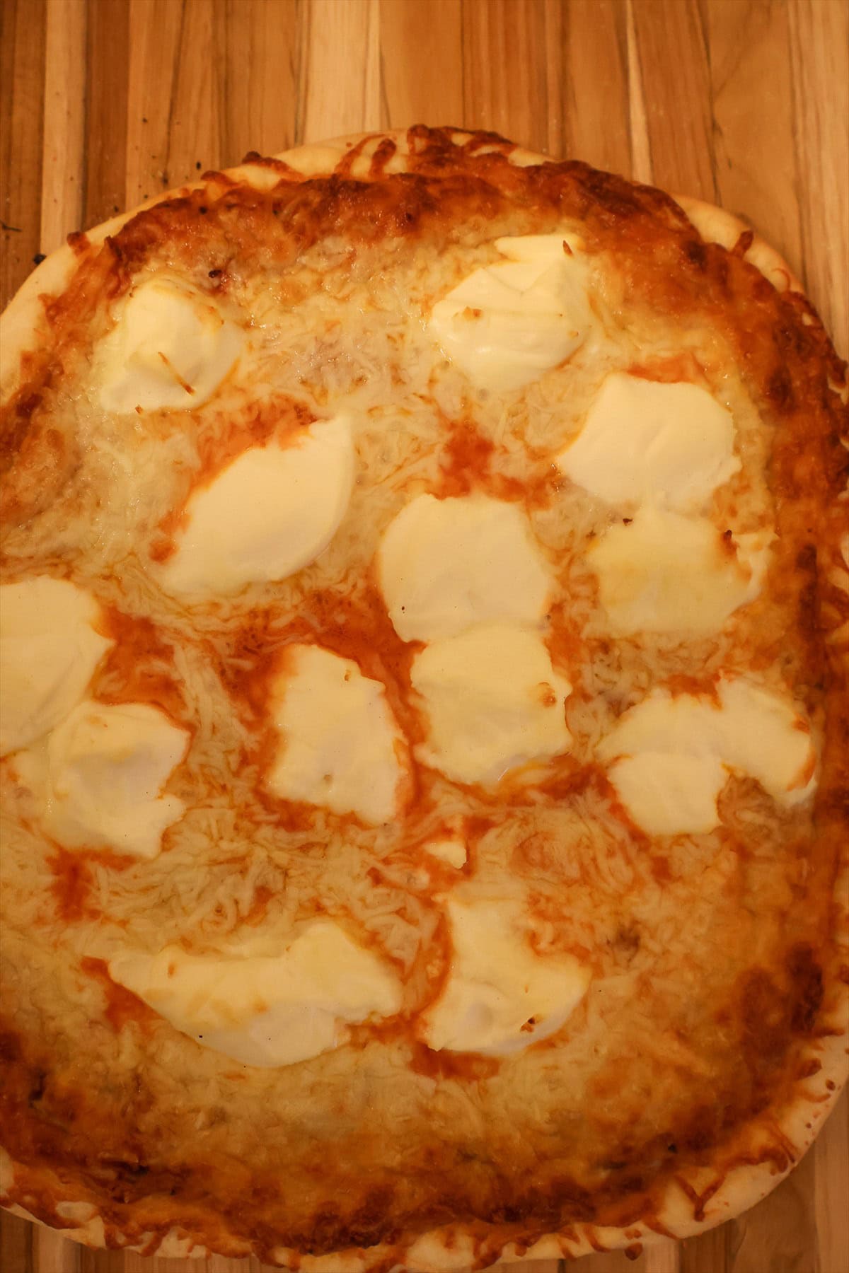 Baked smoked pizza with browned crust and melted three cheese topping fresh off the smoker.