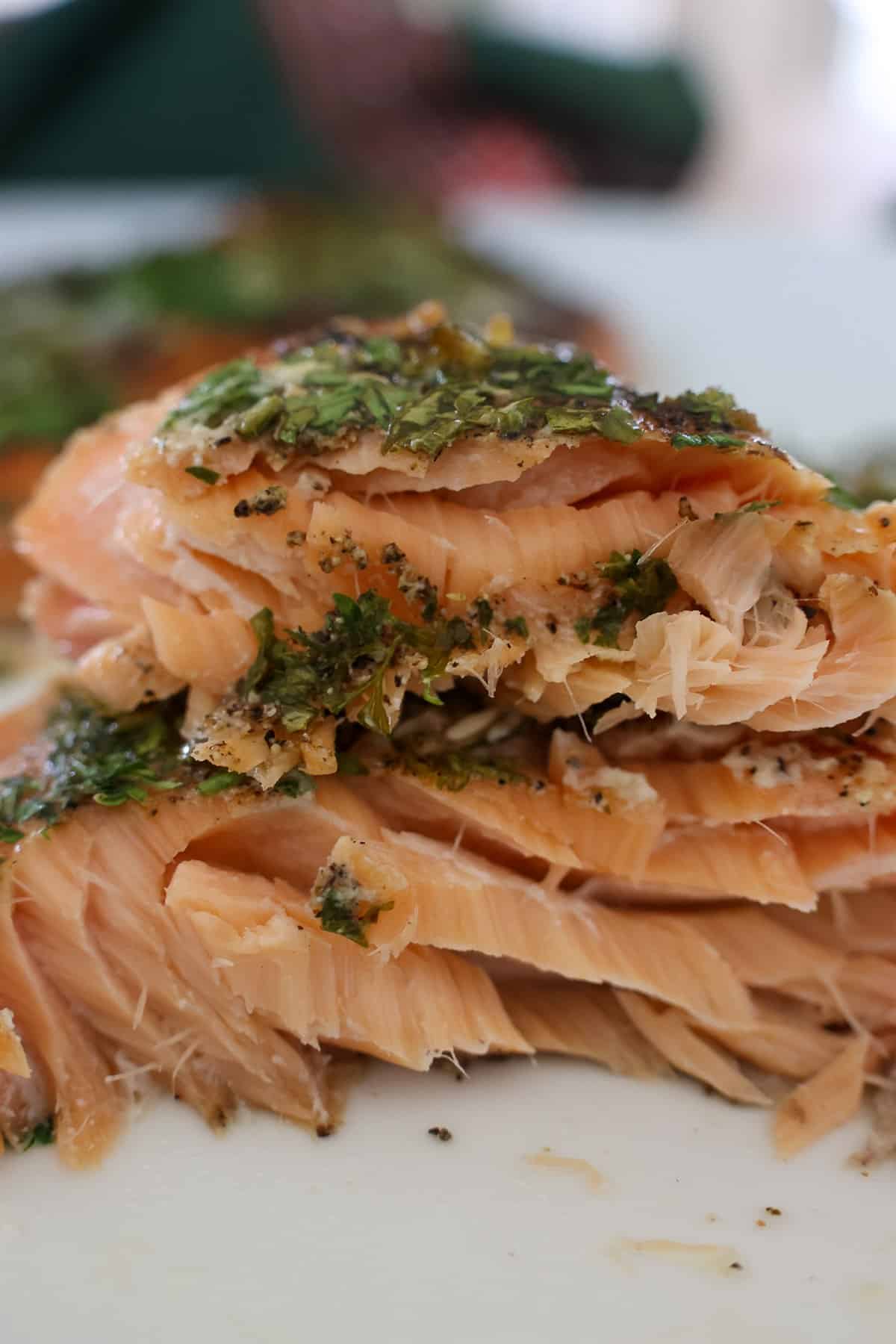 Close up of flaky smoked salmon layers with lemon butter and fresh herbs from this Smoked Salmon Recipe.