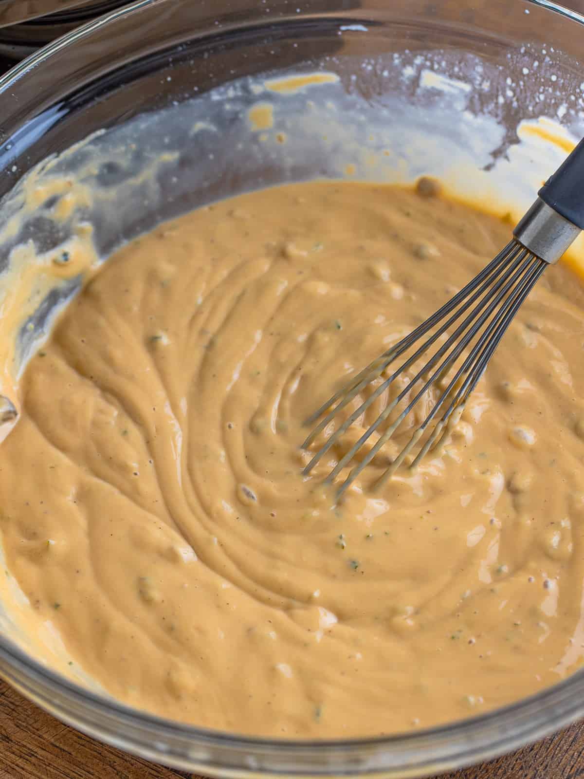 Cream of mushroom soup, au jus gravy mix, and seasonings whisked smooth in a glass bowl.